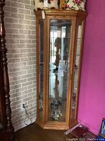 Front angle showing the corner curio cabinet with glass door and shelves, oak finish.