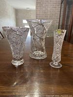 Full view of all three crystal vases showing varied shapes and pinwheel cut designs