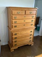 Front view of the six drawer dresser showing wood finish and brass handles.