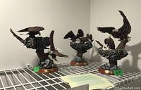 Three eagle figurines from the Protectors of the Nest collection by the Bradford Exchange displayed together on a metal shelf, showing overall size and design.