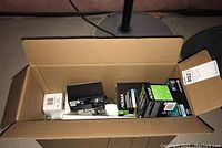 Large cardboard box containing assorted light bulbs in various packaging.