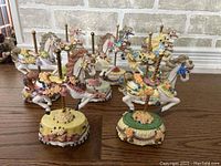 Collection of 8 hand-painted carousel horse music box figurines from Heritage House Melodies Country Fair Collection. Each figurine features a different painted design and tune.