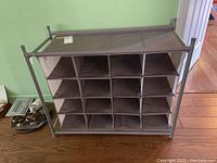 Front view of the metal frame storage unit showing 16 fabric divided compartments for shoes or small items.