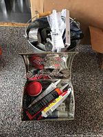 Metal decorative boxes filled with various tubes of adhesives and small hardware items.