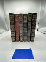 Front view of five standing Easton Press leather bound books showing spines with gold embossed titles.