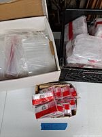 Overview of multiple Apple-branded coin bags in clear plastic packaging, stored in boxes and crates.