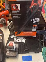 Black & Decker 40V Lithium blower/vacuum set including blower tool, battery in charger, collection bag, original box, and accessories.