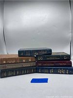 Front view of six leather-bound books by Ernest Hemingway, showing various spine colors and titles.