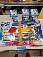 Photo of the open train set box showing pink locomotive and several train cars with track pieces inside original packaging.