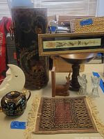 Full lot of umbrella holder, teapot, prayer rug, decorative objects including wooden and glass figurines, framed art, and moon lamp