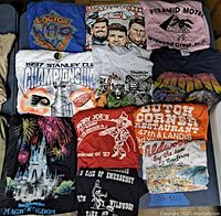 Lot overview showing 11 vintage graphic t-shirts with various themes and colors.