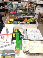 Open white inner box with track pieces, controllers, vehicles, Radar Trap and paperwork laid out