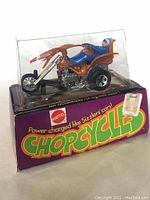 Trike displayed in original blister packaging box under clear plastic cap showing front and side view