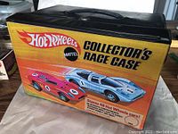 Front view of the Hot Wheels Collector's Race Case showing the brand graphics and race cars illustration.