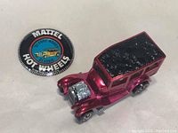 White-background overview showing the red ’31 Ford Woody and round Hot Wheels button side by side