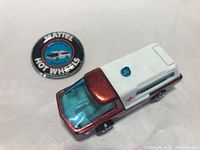 Ambulance and round Hot Wheels button displayed from above