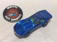 Blue Mattel Hot Wheels Redline Custom Corvette diecast car with wear and button badge