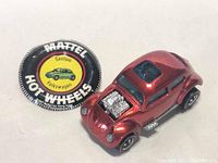 Vintage Mattel Hot Wheels Custom Volkswagen redline die-cast toy car with exposed engine detail and blue windows photographed from front and side angles.
