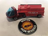 Fire engine toy and button laid out together on white background