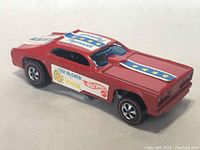 Close angle photo of red Hot Wheels Mongoose redline car showing side decals and racing style design