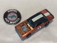 Car and round button badge on white background, front left angle