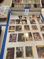 Three-tiered cardboard box brimming with loose basketball cards and a spread of laid-out cards in front