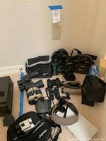 Wide view of all binoculars on carpet with cases and boxes
