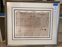 Full view of framed document on shelf with sticker