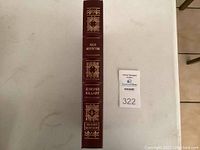 Spine view of maroon leather-bound book with gilt title, author name and 'Signed Edition' embossing