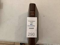 Spine view of one book showing brown leather binding with gold embossed text 'Imitation of Christ' and raised bands.