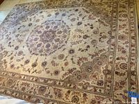 Large rectangular area rug laid out on floor showing central medallion and floral design.