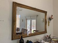 Frontal view of the mirror on wall reflecting dining area