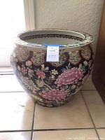 Front view of the oriental planter pot showing floral pattern around the circumference.