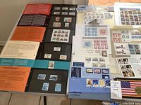 Black binder pages showing mounted commemorative and definitive stamps.