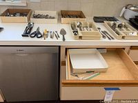 Overview of flatware and utensils on kitchen counter and in drawer.