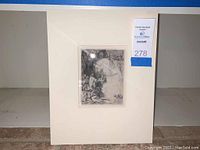 Frontal view of matted etching print upright with auction lot sticker