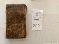 Front cover of leather-bound book with auction lot tag