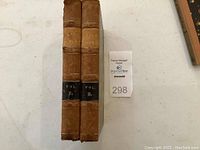 Two volumes of The Works of Thomas Gray with visible spine labels Vol. 1 and Vol. 2 on a table with auction lot tag 298