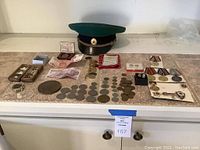 Overview of all items including Soviet military cap, watch, coins, banknotes, medals and badges