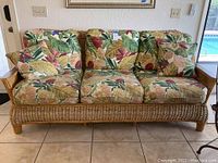 Front view of wicker sofa with three cushions