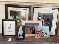 Overview of the six framed wildlife artworks arranged on the floor showing variety in subjects and sizes.