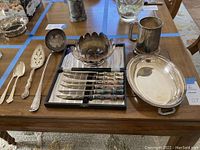 Overview of all silver pieces arranged on wooden table