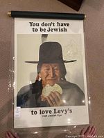 Full view of poster rolled on black top and bottom bars laid flat on carpet