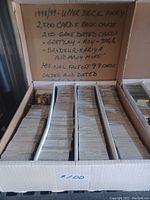 Box with handwritten label describing 2,500 cards from 1998-1999 Upper Deck hockey set, including base cards, 200 game-dated, 180 NHL face-off 99 and other special cards