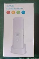 Photo of the retail box for 2 Pack LED Night Light. Shows key features such as motion sensor, energy saving, environment friendly, and 3-level brightness.