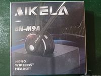 Retail boxed Aikela BH-M9A mono wireless headset showing front of packaging with product image and branding.
