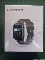 Photo of sealed box packaging for L8STAR fitness tracker smartwatch showing product image with water droplets to indicate water resistance.
