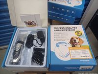 Professional pet hair clipper kit in original packaging showing clipper, charger, comb attachments, and instruction manual.