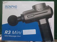 Photo of retail box of Renpho R3 Mini Massage Gun, model RP-OMT17, showing product image and branding.