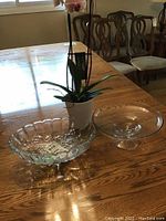 View of two glass servings bowls on table with orchid plant in white pot